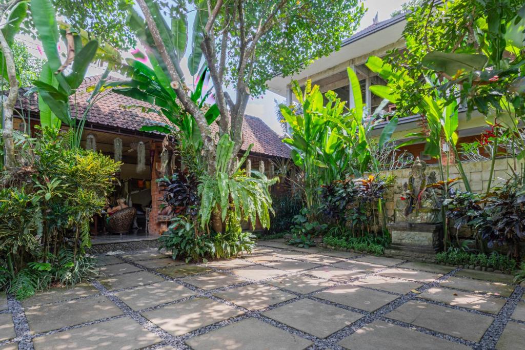 a garden in front of a house with plants at Alam Pracetha Bali Ubud in Ubud