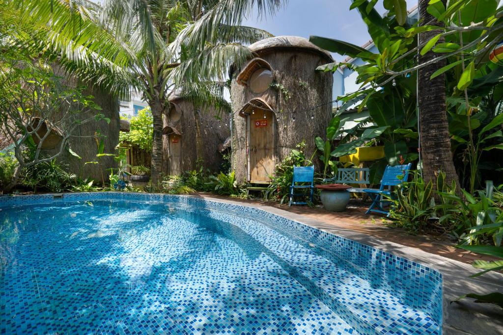 a swimming pool in front of a house at Cocohut Hoi An Homestay in Hoi An