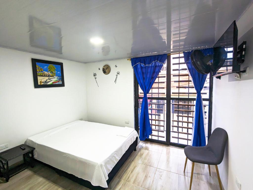 a bedroom with a bed and a large window at Apartaestudio para estrenar La Quinta in Ibagué