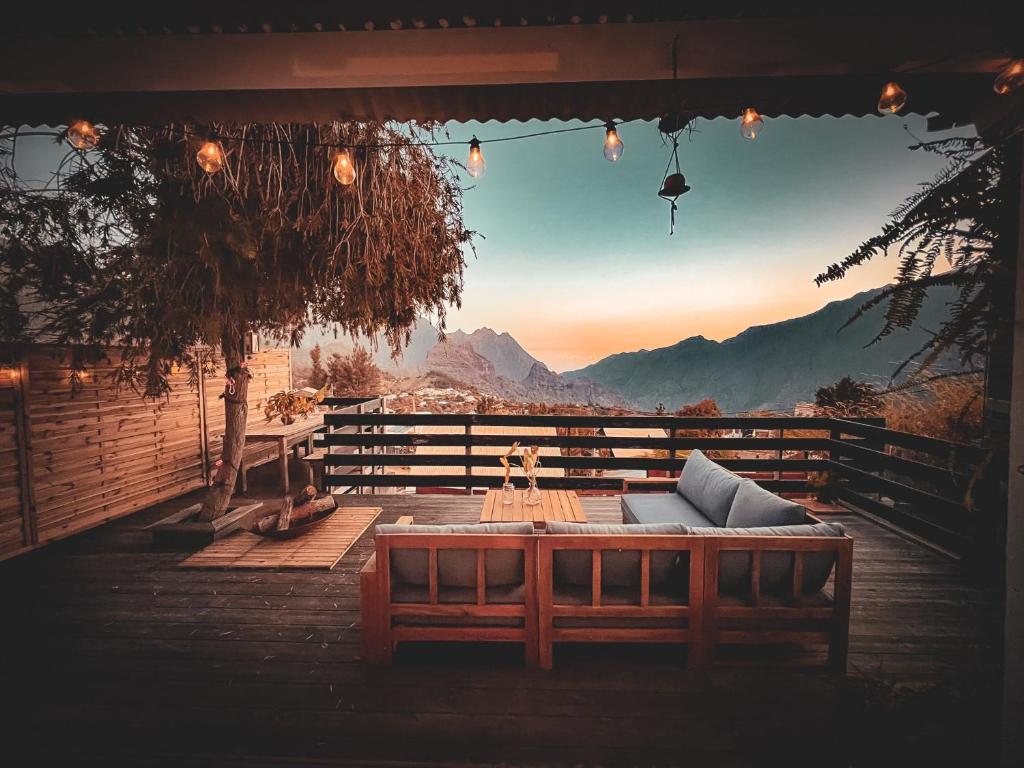 a patio with a table and a view of the mountains at Ti'Laos in Cilaos
