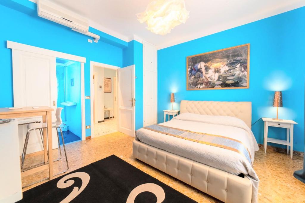 - une chambre avec un lit et un mur bleu dans l'établissement Pisa Happy House, à Pise