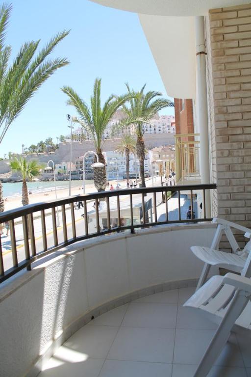 a balcony with a view of the beach and palm trees at Apartamento Avenida Mar in Peniscola