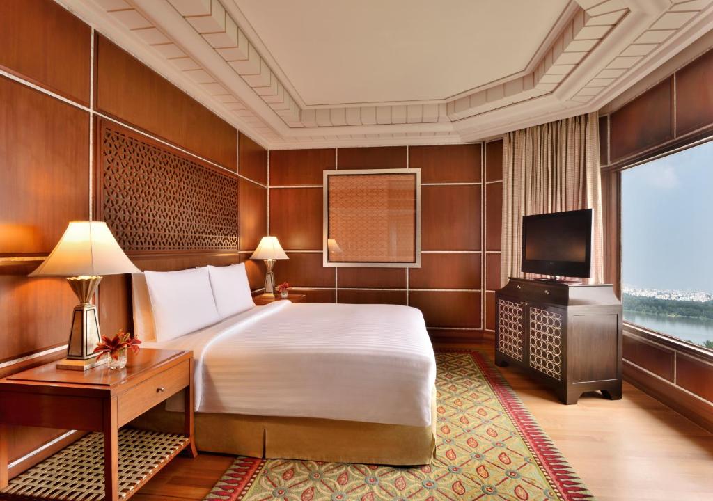a bedroom with a bed and a desk and a television at Hyderabad Marriott Hotel & Convention Centre in Hyderabad