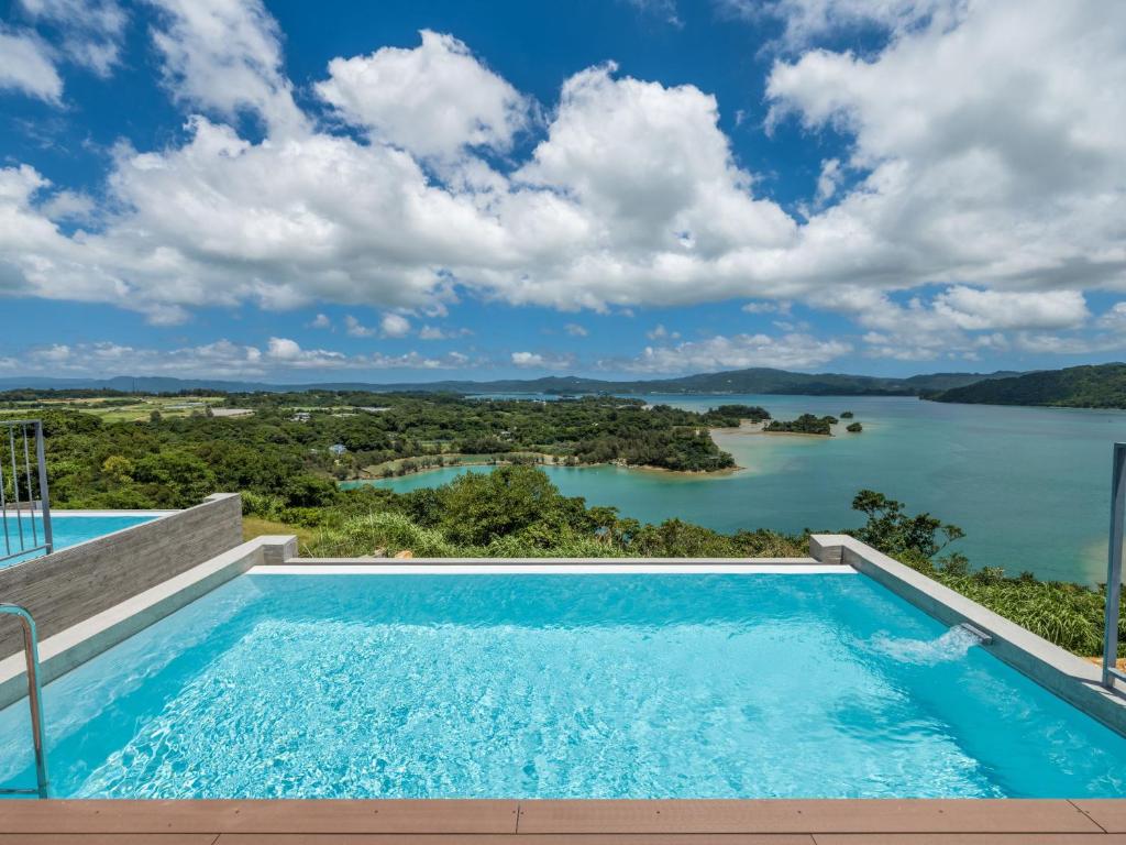 einen Pool mit Blick auf einen Wasserkörper in der Unterkunft K-Style-Resort-SEVEN Hotels and Resorts- in Nakijin