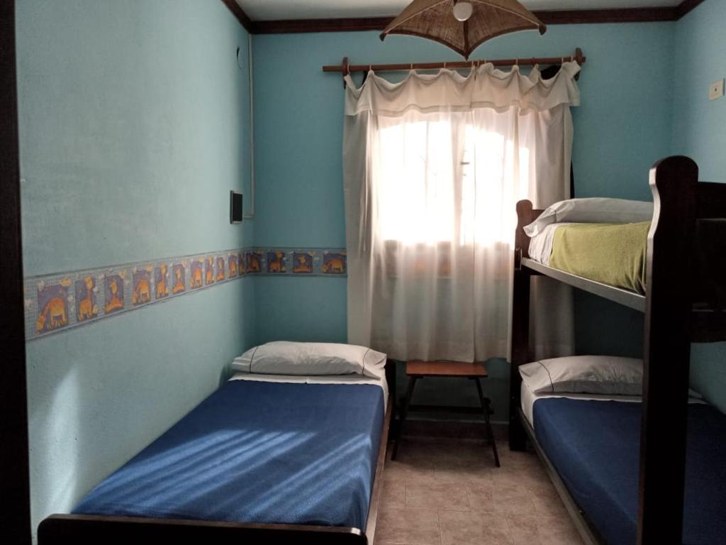 Zimmer mit 2 Etagenbetten und einem Fenster in der Unterkunft Cabaña Los Lirios in Huerta Grande