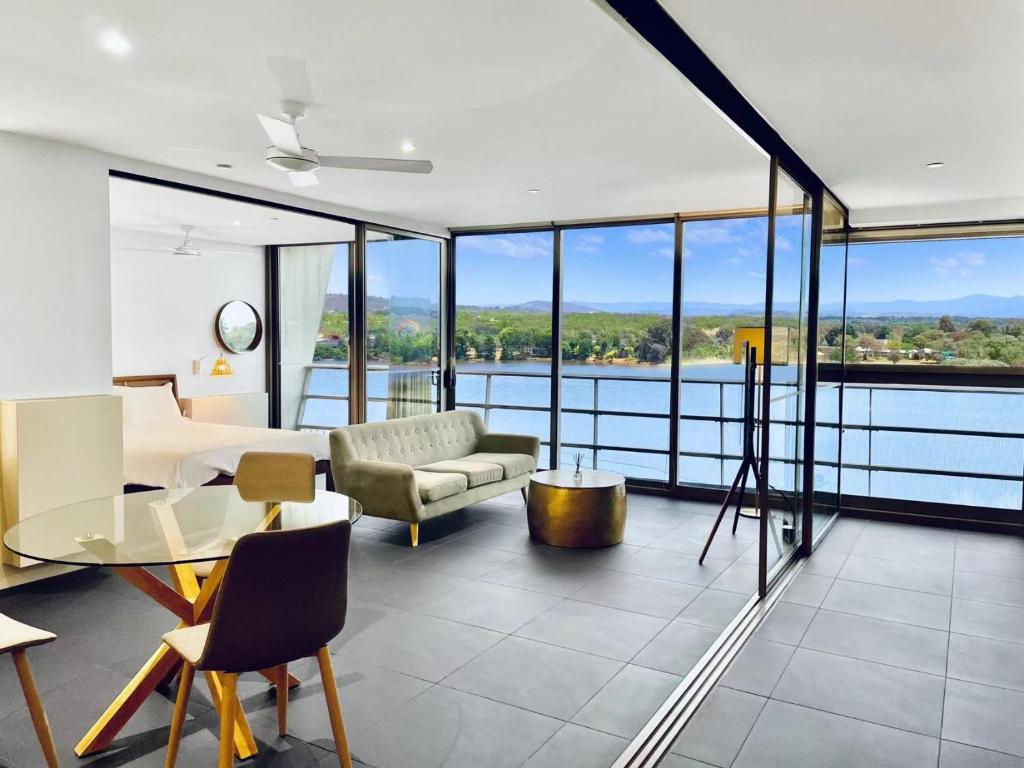 een woonkamer met uitzicht op het water bij Nishi Holiday Apartments in Canberra