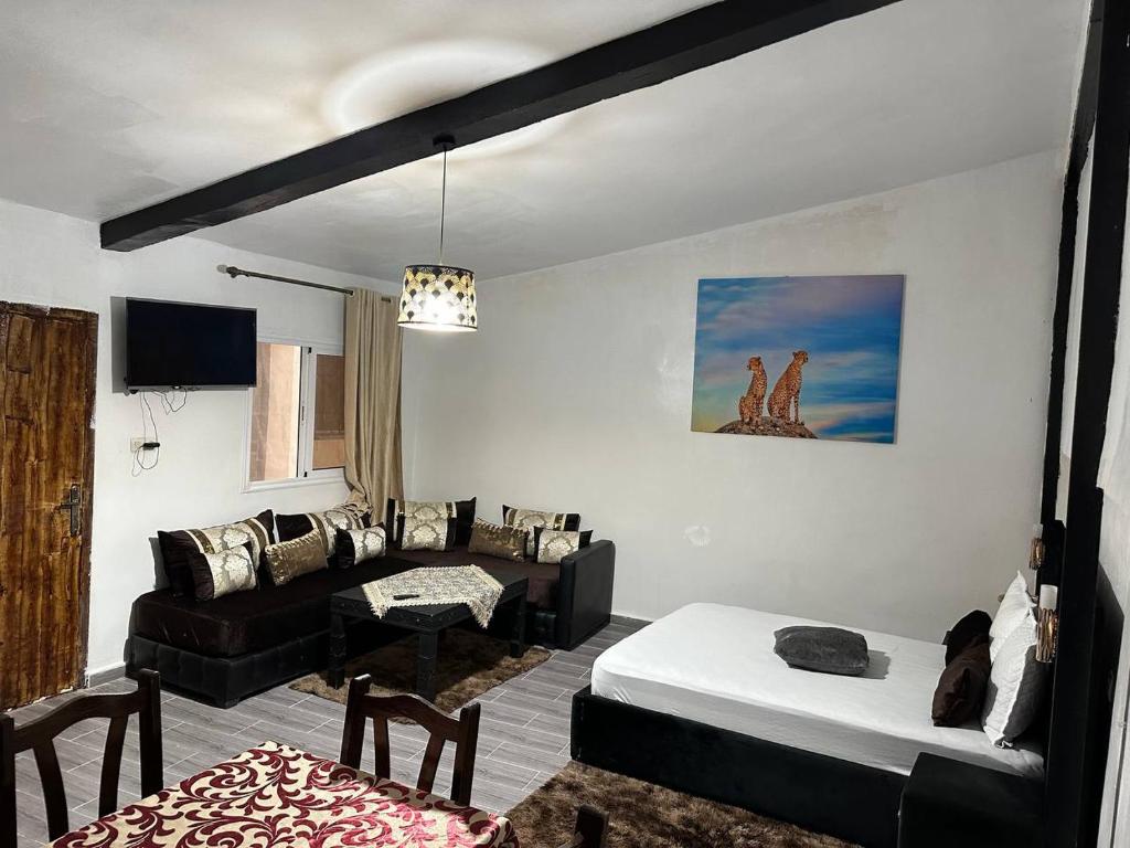uma sala de estar com uma cama e um sofá em La pivoine jaune em Ifrane