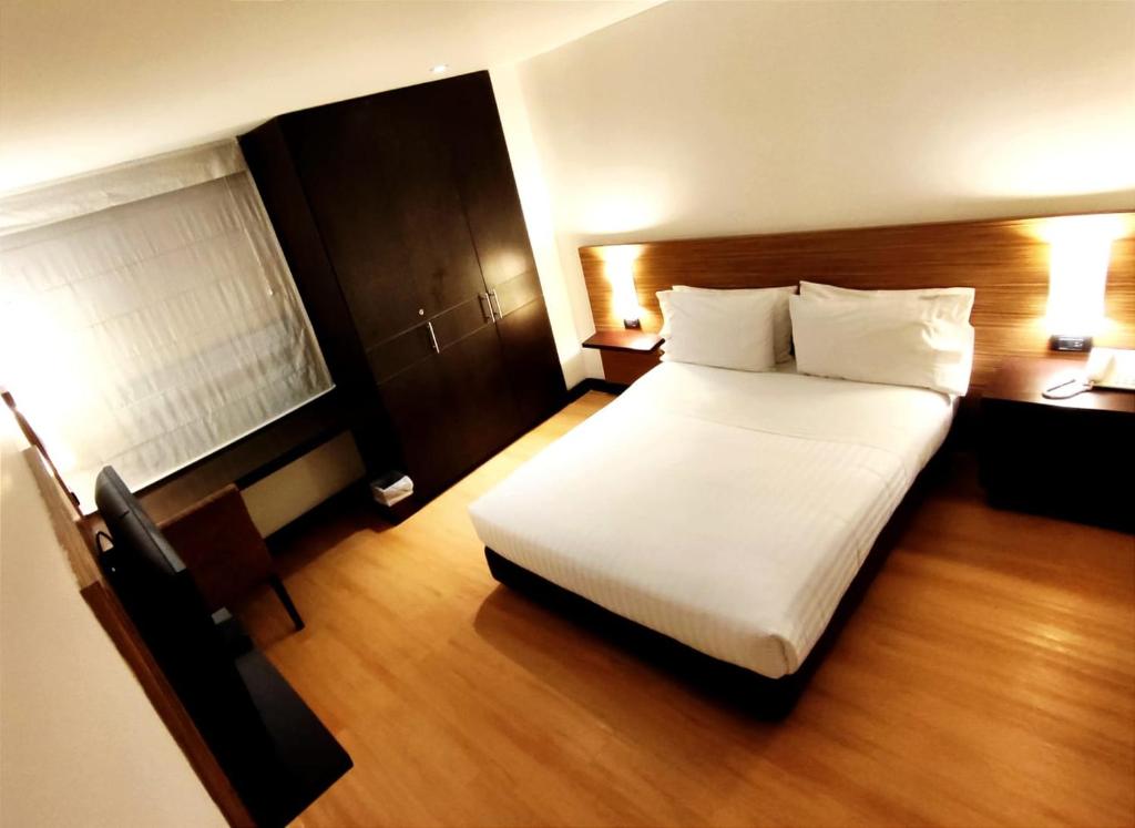 a bedroom with a large white bed and a desk at Scala 68 in Bogotá