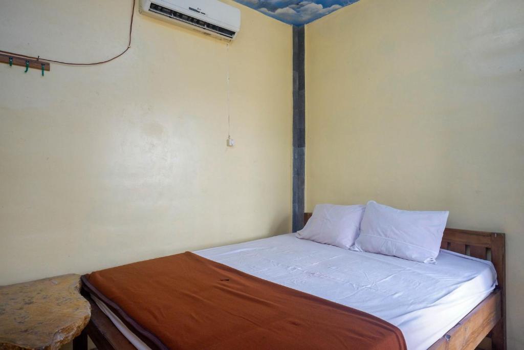 ein kleines Schlafzimmer mit einem Bett in einem Zimmer in der Unterkunft Hotel Kampoeng Drini RedPartner in Brono