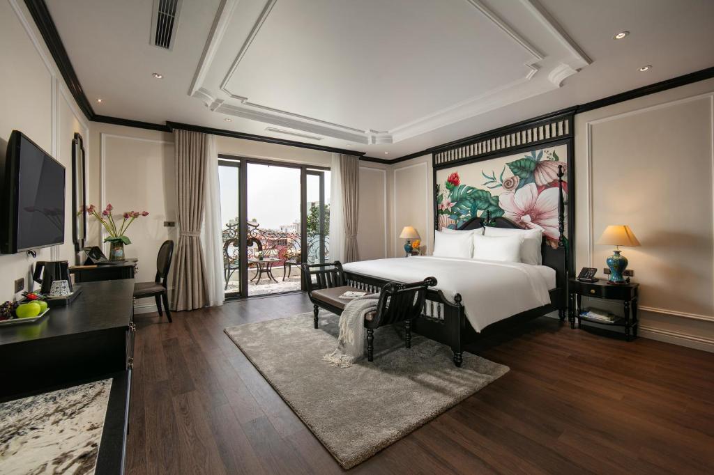 a bedroom with a large bed with a painting on the wall at Amira Hotel Hanoi in Hanoi
