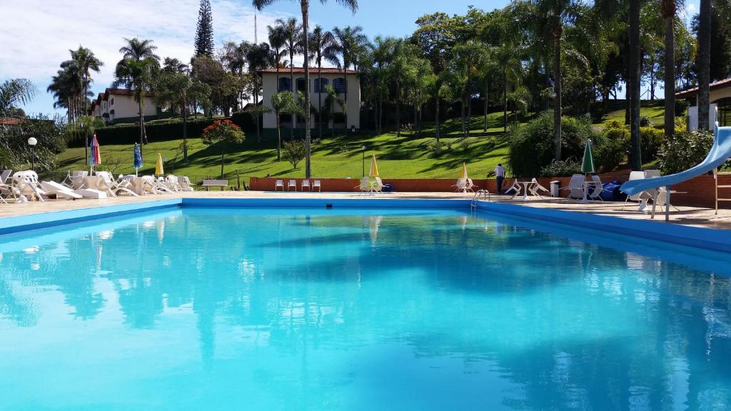 une grande piscine bleue avec toboggan dans l'établissement Hotel Fazenda São Matheus, à Serra Negra