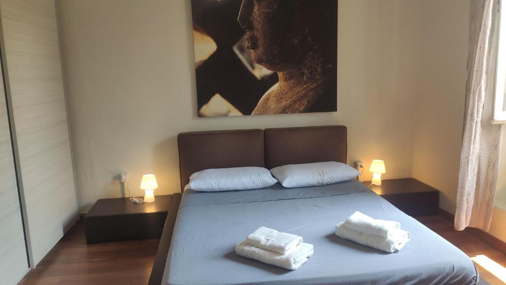 a bedroom with a bed with two towels on it at Casa vacanze in centro in Lecco