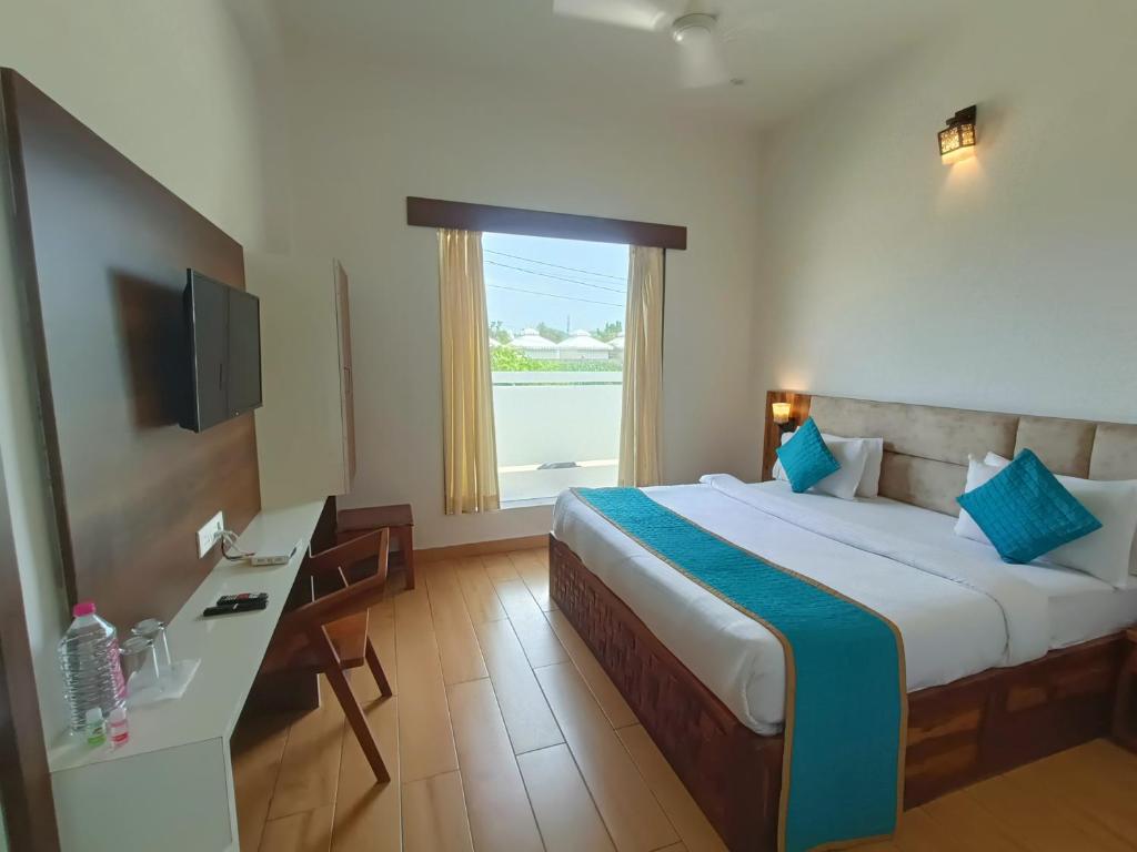 um quarto de hotel com uma cama, uma secretária e uma janela em Hotel Dream Orchid em Pushkar