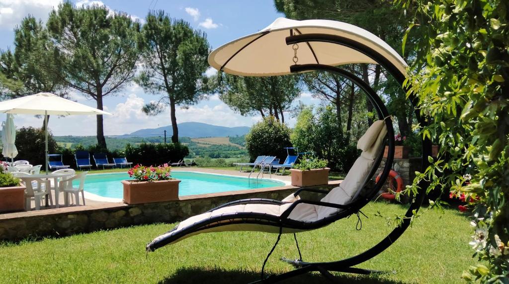 krzesło w trawie obok basenu w obiekcie Agriturismo Il Catrino w mieście Ponteginori