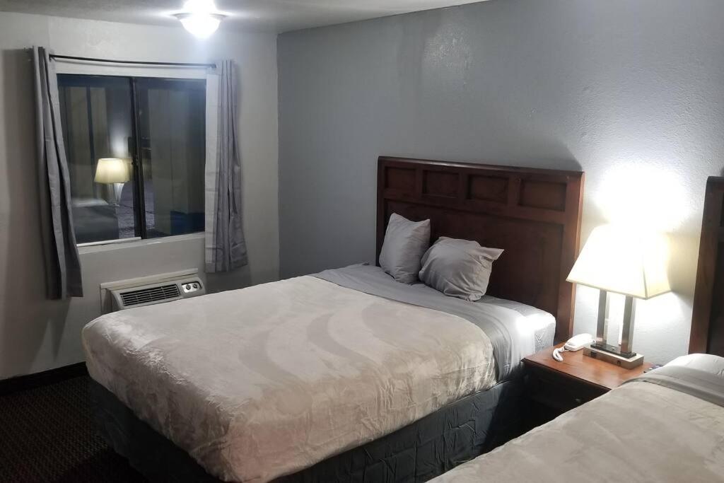 ein Hotelzimmer mit 2 Betten und einem Fenster in der Unterkunft OSU 2 Queen Beds Hotel Room 133 Hot Tub Booking in Stillwater