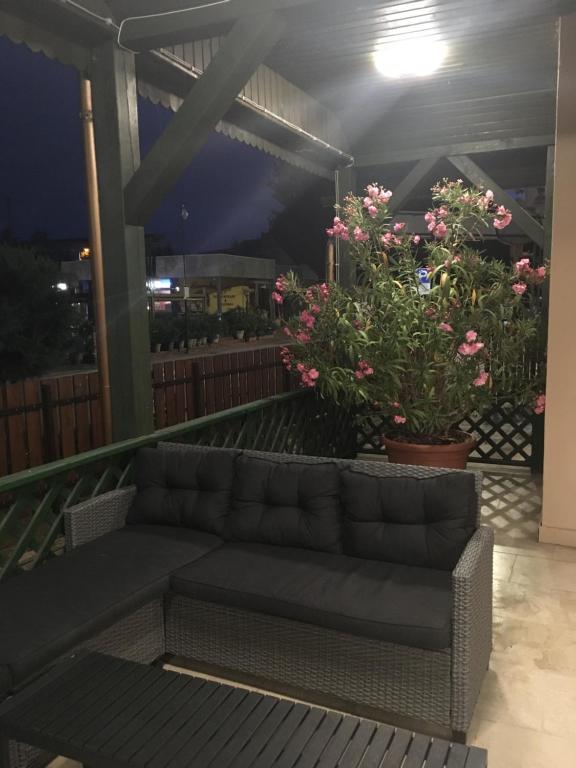 a couch sitting on a balcony with flowers at Fenyves Hotel in Balatonfenyves