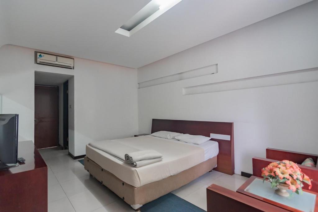Postel nebo postele na pokoji v ubytování Istana Hotel Bandung Mitra RedDoorz