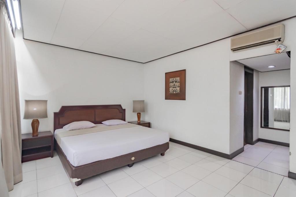 Postel nebo postele na pokoji v ubytování Istana Hotel Bandung Mitra RedDoorz
