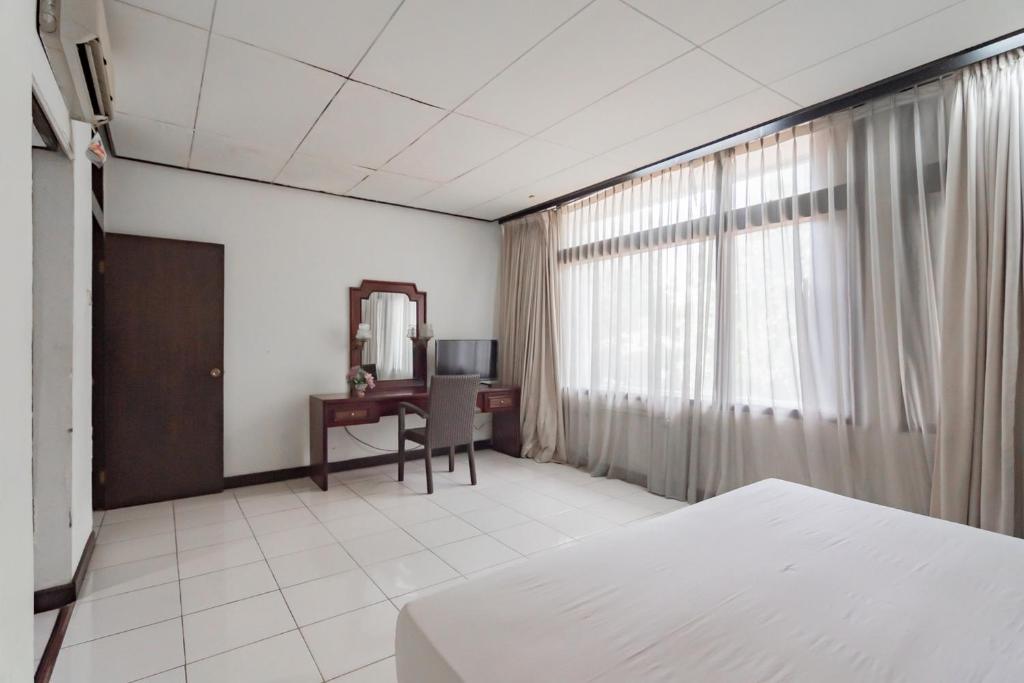 Postel nebo postele na pokoji v ubytování Istana Hotel Bandung Mitra RedDoorz