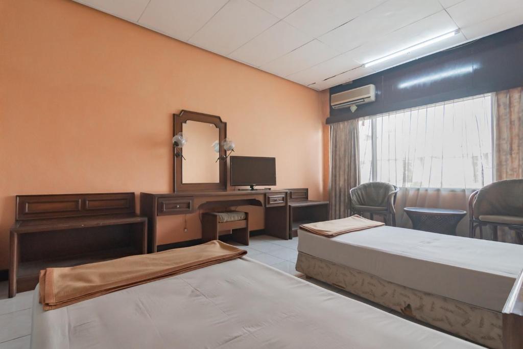 Postel nebo postele na pokoji v ubytování Istana Hotel Bandung Mitra RedDoorz