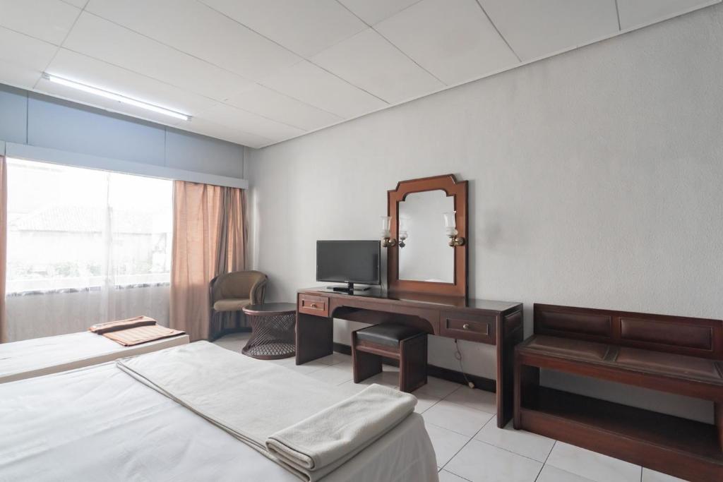 Postel nebo postele na pokoji v ubytování Istana Hotel Bandung Mitra RedDoorz