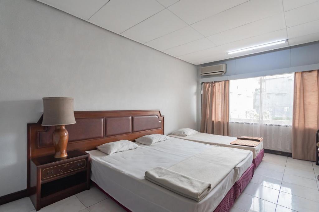 Postel nebo postele na pokoji v ubytování Istana Hotel Bandung Mitra RedDoorz