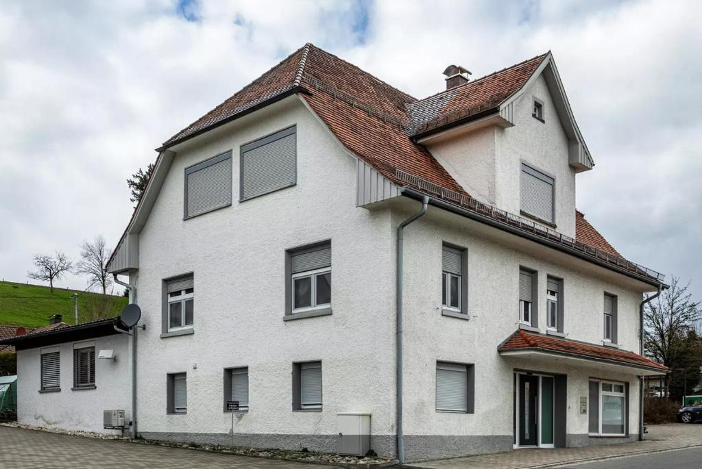 a white house with a brown roof at 2 Zimmerwohnung in 88099 Neukirch ab 2 Übernachtungen in Neukirch