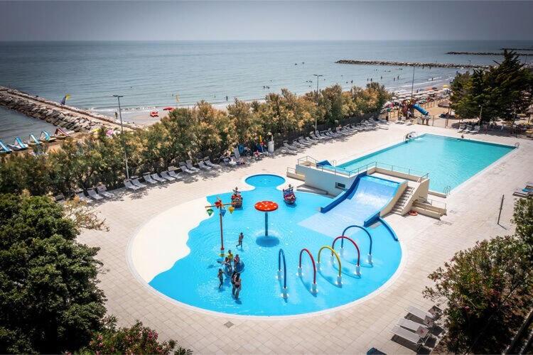 an overhead view of a swimming pool next to a beach at Bungalow in Caorle with garden furniture in Caorle