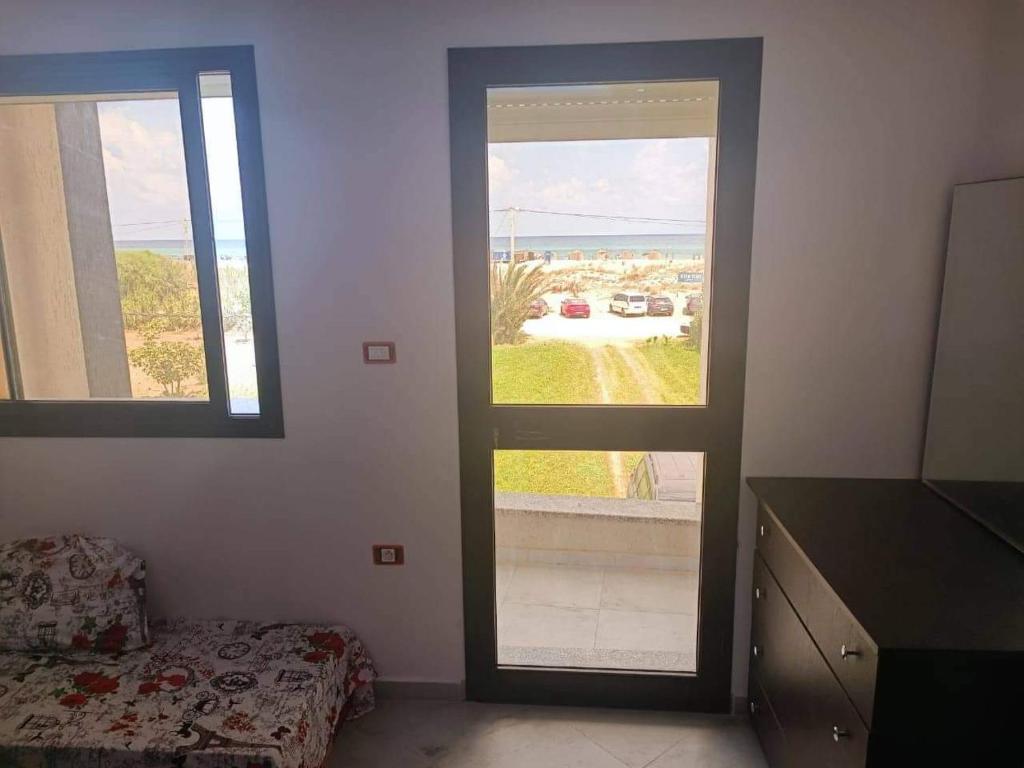 um quarto com duas janelas e um quarto com uma cama em S 2 high standing waterfront in Dar Allouche Kelibia Nabeul em Hanshīr Qaşr Ghallāb