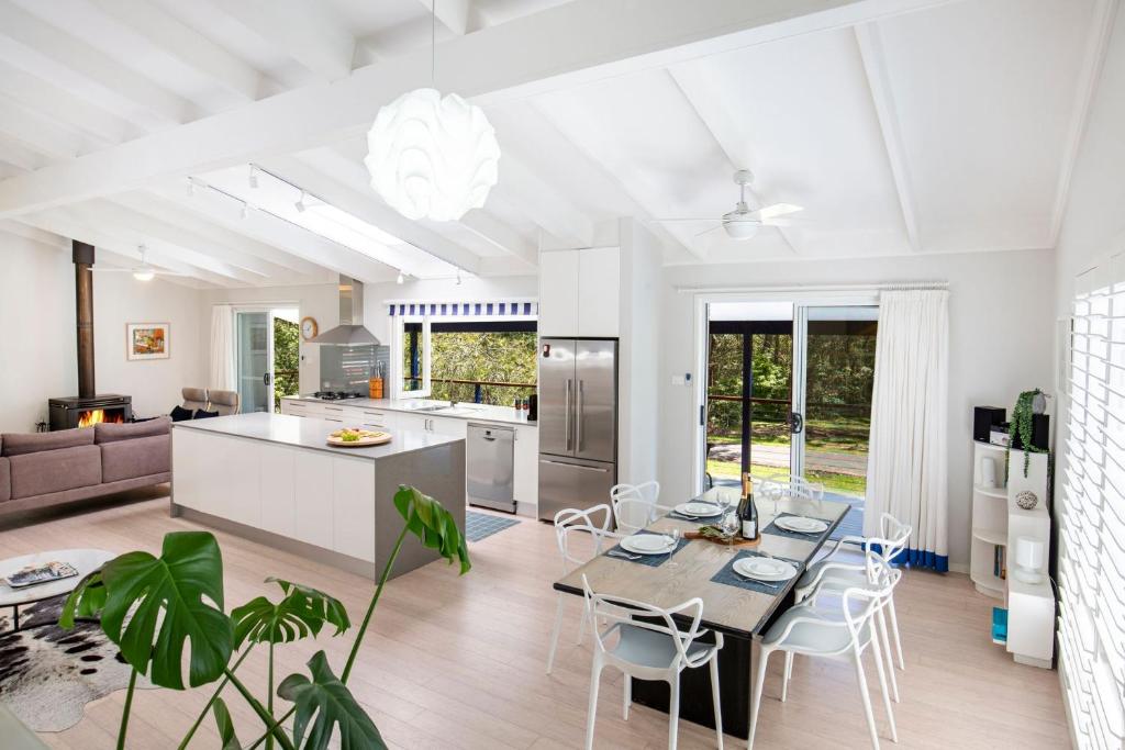 Una cocina y una sala de estar con mesa y sillas. en Mariners Retreat Jervis Bay, en Vincentia