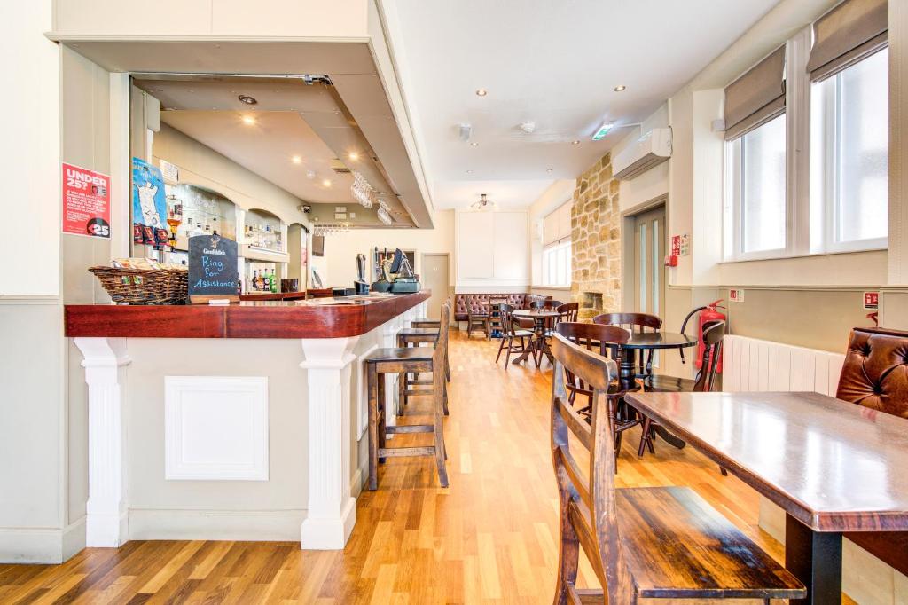 a bar in a restaurant with tables and chairs at The Morar Hotel in Morar