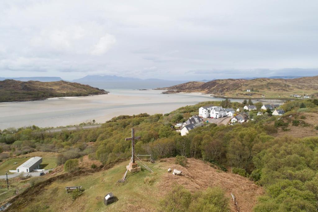 a cross on a hill with a view of a river at The Morar Hotel in Morar