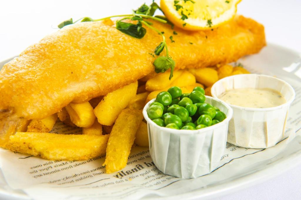a plate of food with fish and french fries and peas at The Morar Hotel in Morar