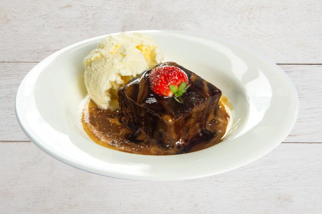 a plate of chocolate dessert with a strawberry and ice cream at The Morar Hotel in Morar