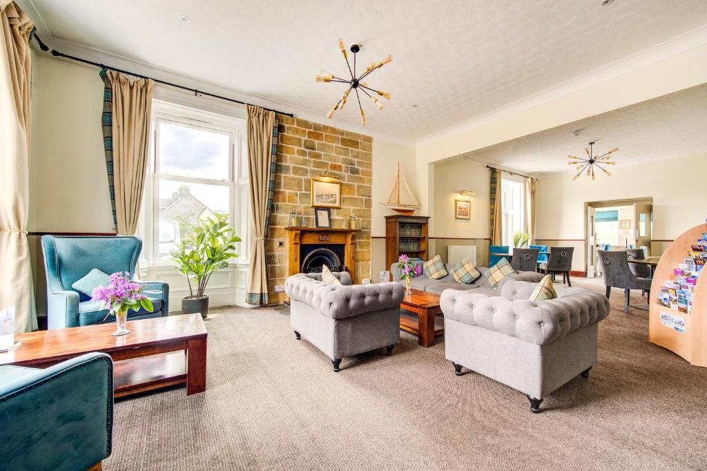 a living room with couches and a fireplace at The Morar Hotel in Morar