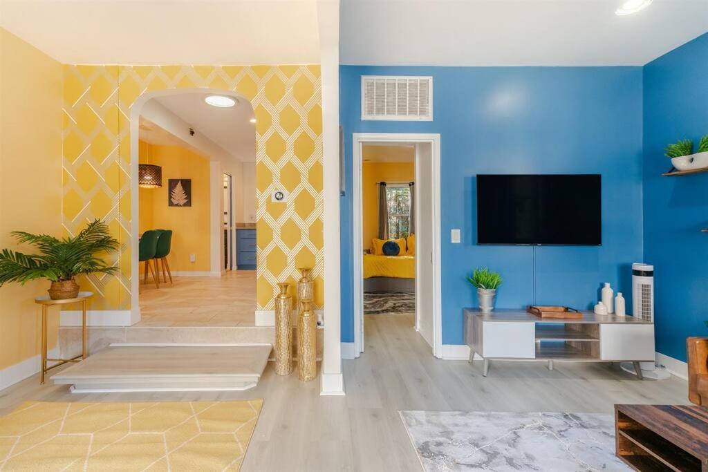 sala de estar con paredes azules y TV de pantalla plana. en Modern Cottage near many conveniences en Oakland
