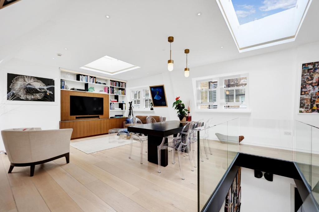 a living room with a dining table and a tv at Luxury 3 Bed House by Hyde Park, Bayswater in London