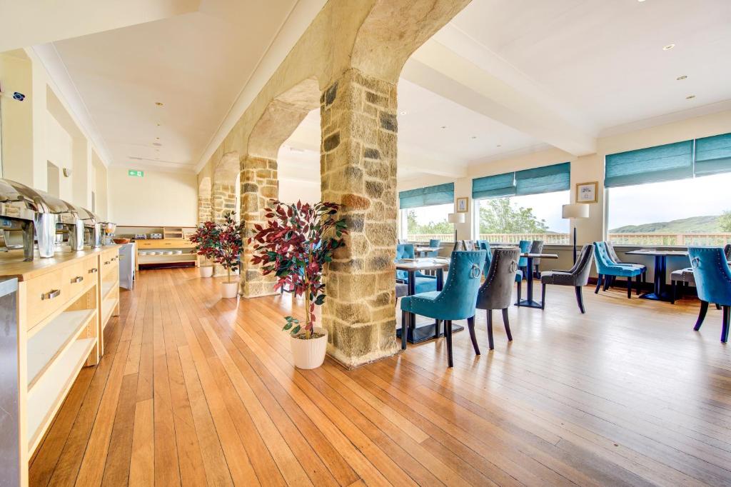 a large dining room with blue chairs and tables at The Morar Hotel in Morar