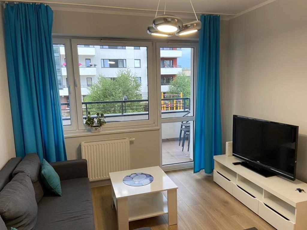 a living room with a couch and a flat screen tv at Apartament Strefa Czasu in Toruń
