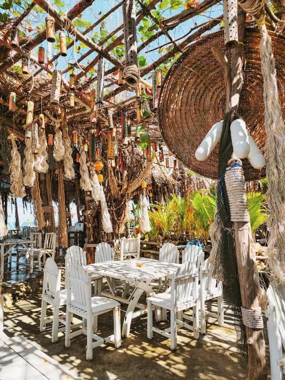 a dining room with white chairs and a table at Haadson Resort & Koh Raham in Haad Son