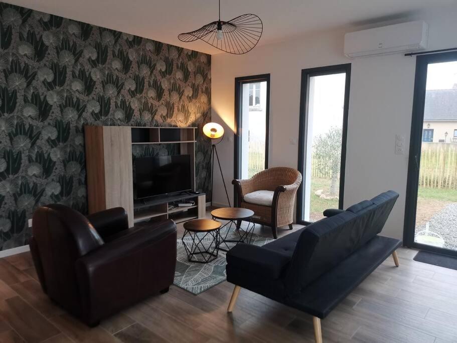 ein Wohnzimmer mit einem Sofa, Stühlen und einem TV in der Unterkunft Maison neuve à 2 pas des plus belles plages de Douarnenez - Classé Meublé de Tourisme 3 étoiles in Kerlaz