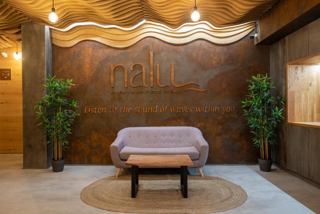 una sala de espera con sofá y mesa en NALU Valencia Boutique Rooms, en Valencia