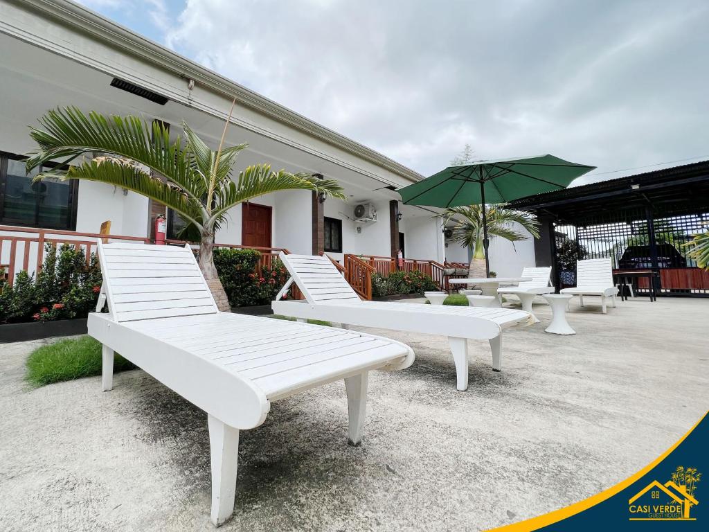 un groupe de bancs blancs assis à l'extérieur d'un bâtiment dans l'établissement Casi Verde Guest House, à Panglao