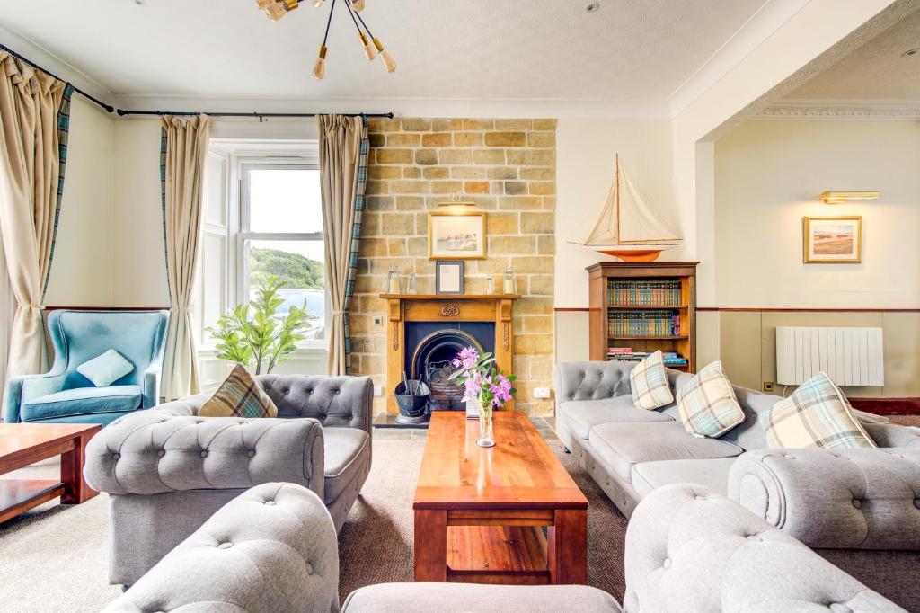 a living room with couches and a fireplace at The Morar Hotel in Morar
