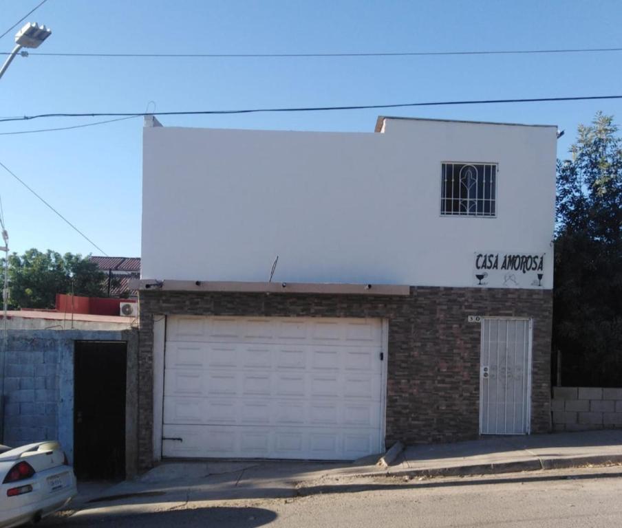 un bâtiment avec deux portes de garage et un panneau sur celui-ci dans l'établissement Casa Amorosa, à Tecate
