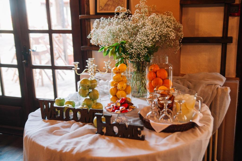 a table with fruits and a vase of flowers at Pliades Traditional Guesthouse in Palaios Panteleimonas