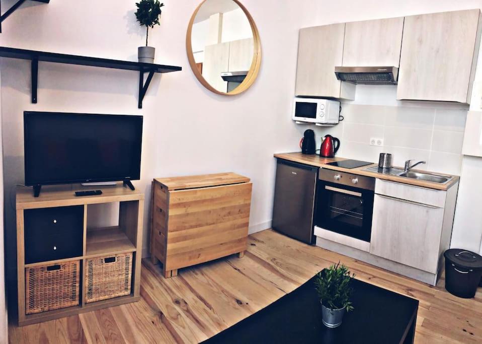 a small kitchen with a television and a counter at Agréable T2 cosy proche du centre de Bayonne in Bayonne
