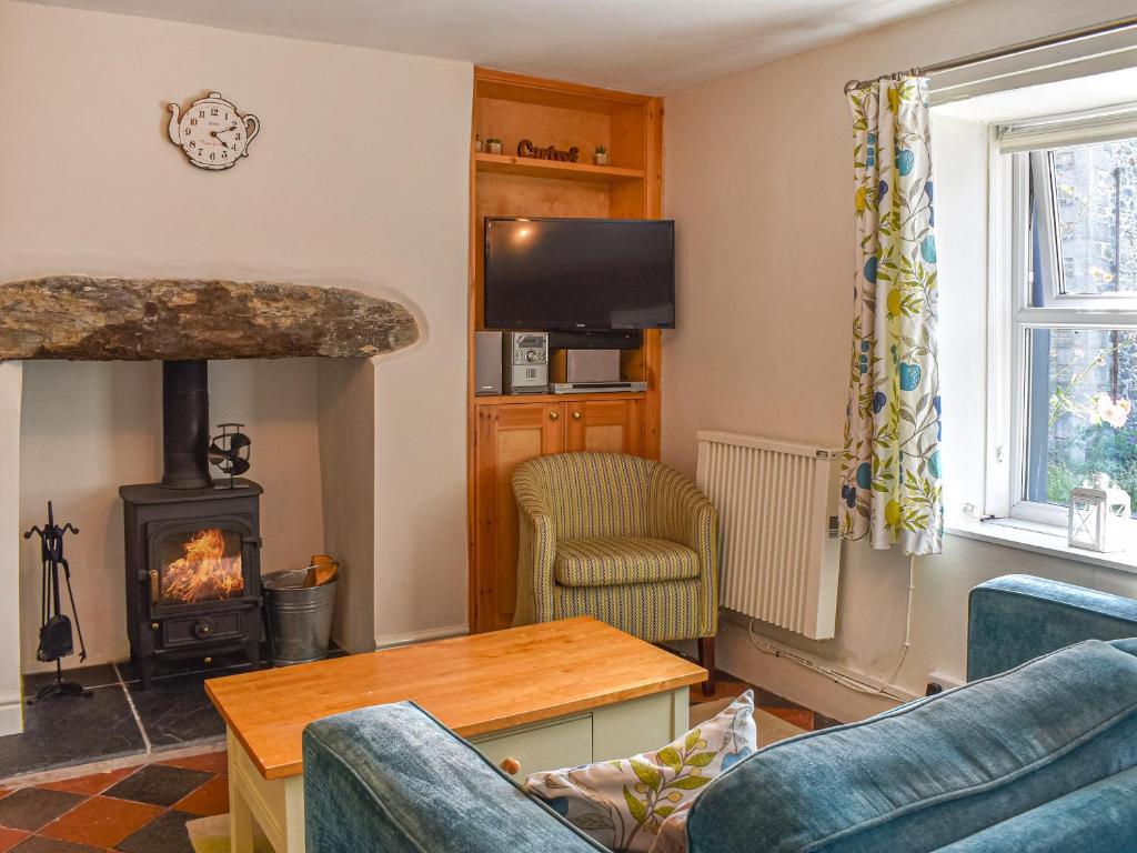 a living room with a fireplace and a wood stove at Tyn Y Berth in Talsarnau