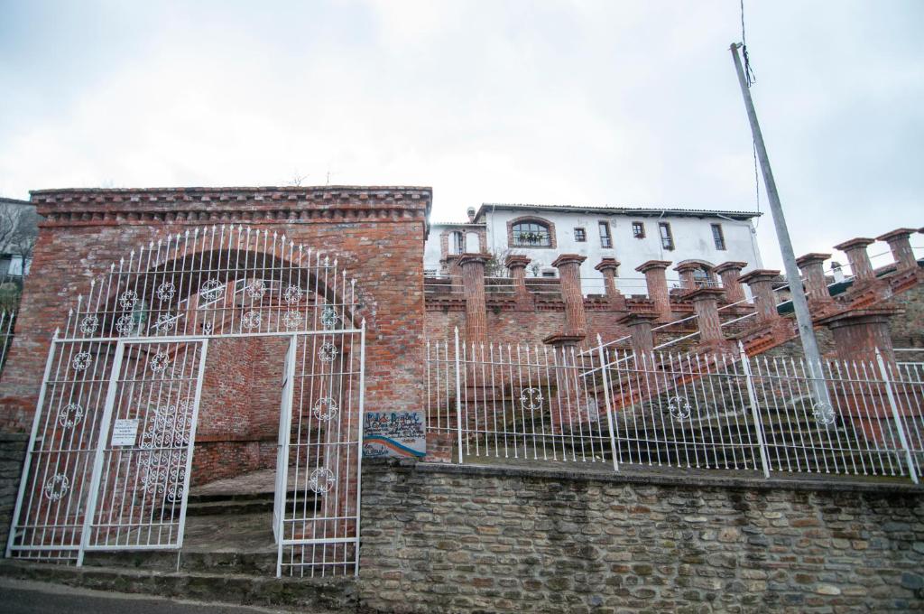 ein Backsteingebäude mit einem Tor davor in der Unterkunft Room in House - Castello dei Diamanti in Belvedere Langhe