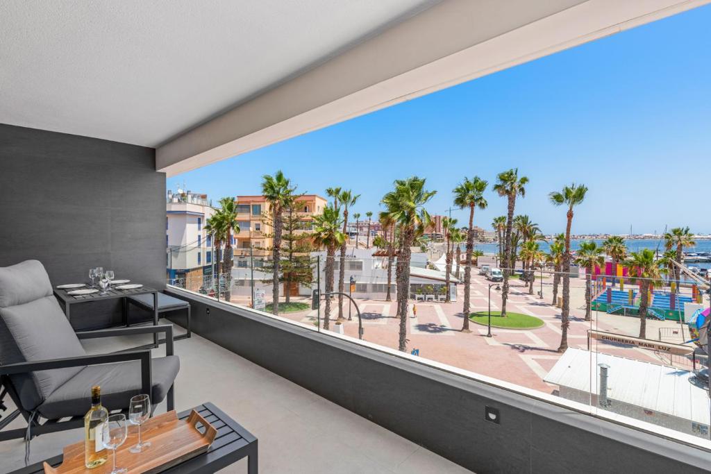 balcón con vistas a la playa y a las palmeras en Elegance Seaside Retreat, en San Pedro del Pinatar